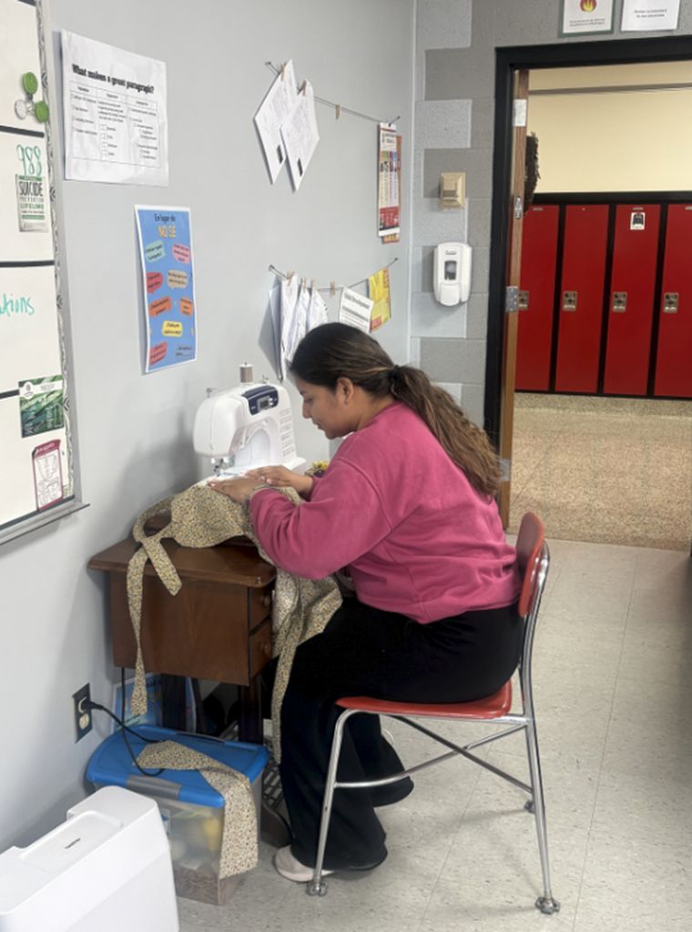 student sewing an apron